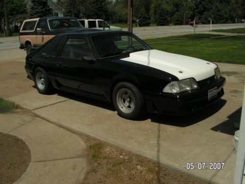 1988 Ford Mustang - This 1988 Ford Mustang has a contrasting white hood and is parked on a concrete driveway.