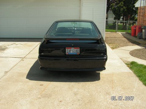 1988 Ford Mustang - Rear view of a black 1988 Ford Mustang hatchback with a spoiler and a license plate.