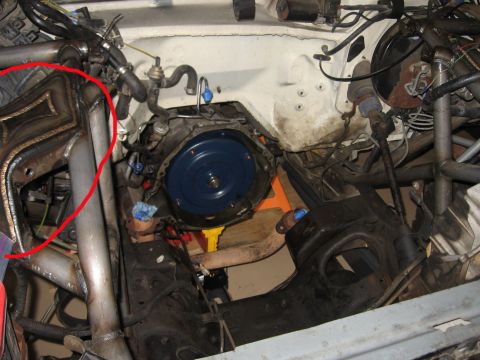 1990 Ford Bronco - bare engine bay showing the transmission bellhousing, with a red hand-drawn circle highlighting a header on the left.