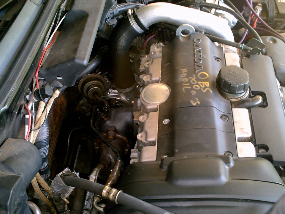 Volvo engine bay with black valve cover marked in yellow paint pen