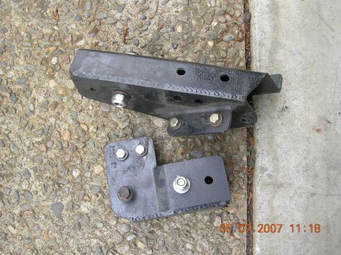 1996 Ford Bronco - Two aftermarket suspension brackets are shown on a gravel and concrete surface.