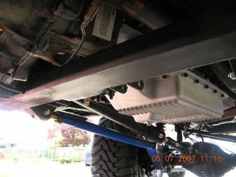 1996 Ford Bronco - A close-up view of a vehicle's undercarriage reveals its mechanical components and suspension system.