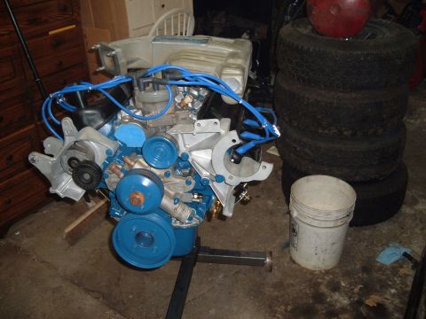 1990 Ford Ranger - Rebuilt Ford V8 engine with blue spark plug wires, mounted on a stand in a garage.