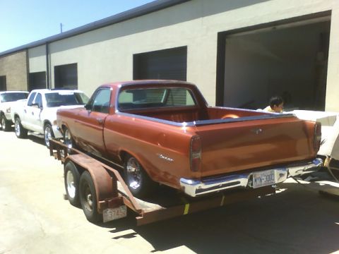 1979 Ford Ranchero - This pickup truck, likely from the early 1970s, is being transported on a trailer alongside two white pickup trucks.