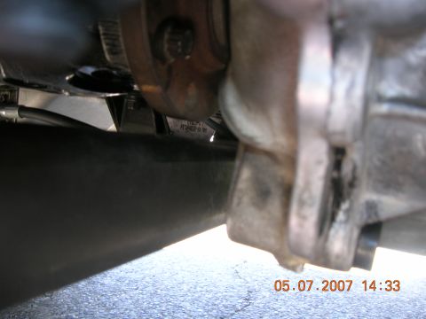 1996 Ford Bronco - Close-up view of a vehicle's exhaust system components, showing a metal bracket and pipe.