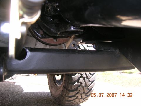 1996 Ford Bronco - A close-up shot of the undercarriage reveals heavy-duty suspension parts and a tire with aggressive tread.