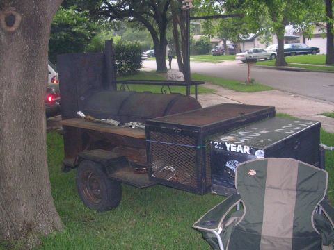 1994 Ford Bronco - A large smoker grill is set up on a trailer in a grassy yard, with text visible on one of its storage boxes.