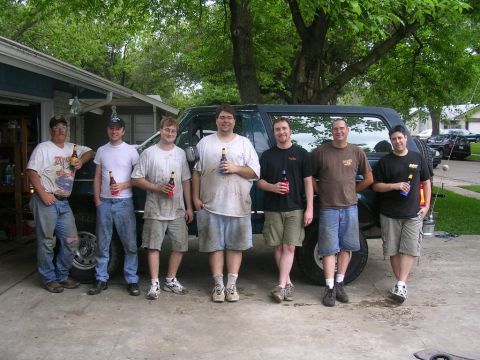 1994 Ford Bronco - Friends gather around a 1994 Ford Bronco, holding beer bottles.