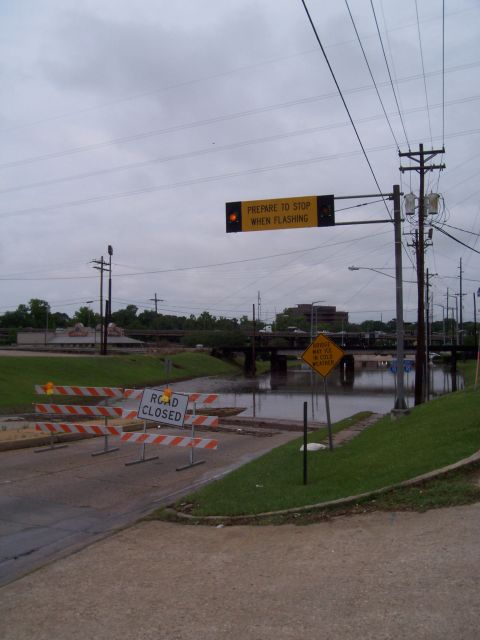 1992 Ford Bronco - Road closed due to flooding, with barriers and a flashing signal indicating the hazard.