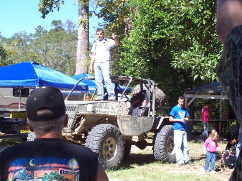 1992 Ford Bronco - A man stands on a custom off-road buggy while others gather around.