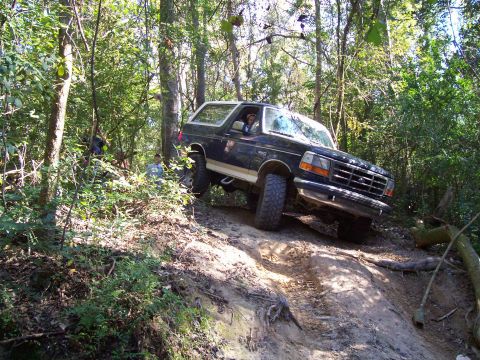 1992 Ford Bronco - A 1992 Ford Bronco navigates a steep, wooded off-road trail.
