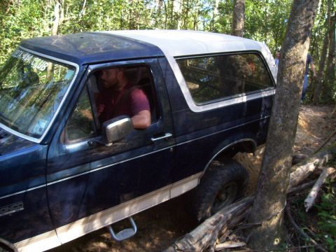 1992 Ford Bronco - This 1992 Ford Bronco navigates a challenging off-road trail through a wooded area.
