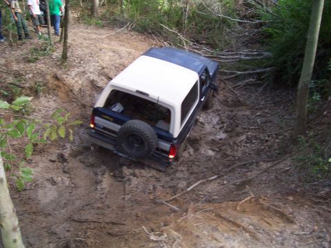 1992 Ford Bronco - This 1992 Ford Bronco is tackling a challenging off-road trail covered in mud and debris.