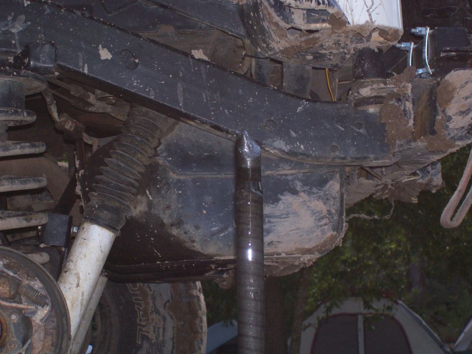 close-up of a dirty vehicle frame and suspension components, possibly during maintenance