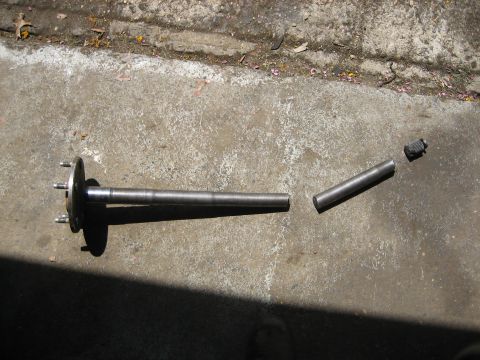1990 Ford Bronco - A broken axle shaft lies in pieces on a concrete surface, indicating a mechanical failure.