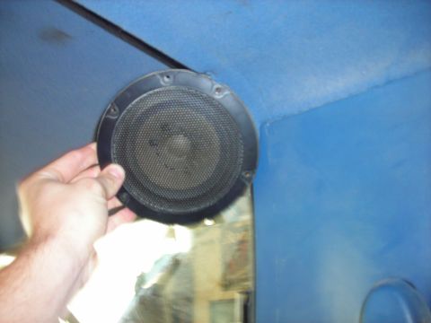 1994 Ford Bronco - A hand holds a speaker in the blue interior of a vehicle. The registry claims it is a 1994 Ford Bronco.