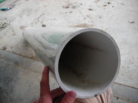 1994 Ford Bronco - A section of pipe is held up, showing its interior and exterior surfaces.