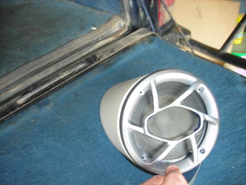 1994 Ford Bronco - A car speaker is shown on a blue carpeted surface, possibly inside a vehicle.