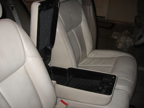 2001 Ford Crown Victoria - The interior of a 2001 Ford Crown Victoria features light-colored leather seats and an open center console storage compartment.
