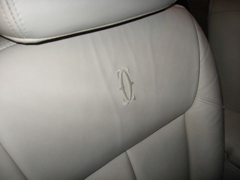 2001 Ford Crown Victoria - Interior shot of a car seat showing a distinctive embossed logo on the headrest.