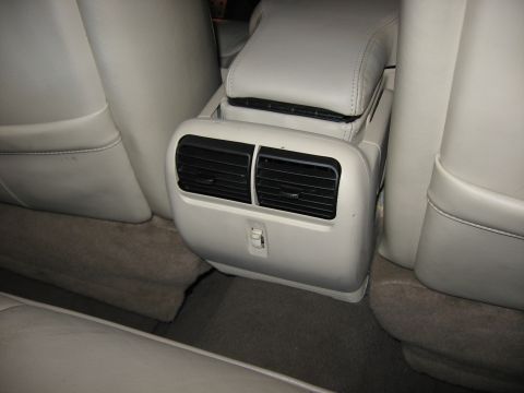 2001 Ford Crown Victoria - The rear passenger area of a car, showing the climate control vents and part of the center console.