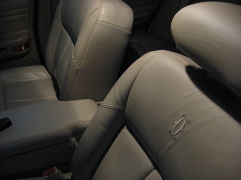 2001 Ford Crown Victoria - Close-up of the interior leather seats, showing stitching and an embroidered emblem on the headrest.