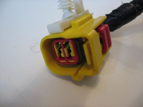 2001 Ford Crown Victoria - This is a close-up view of a yellow and red automotive electrical connector with a black wire bundle attached.