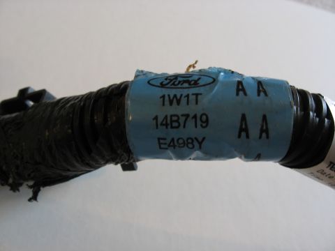 2001 Ford Crown Victoria - A close-up of a Ford wiring harness shows a blue label with part identification numbers.