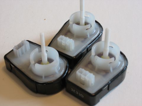 2001 Ford Crown Victoria - Three automotive electronic components are shown, each with a white stem and plastic connectors.