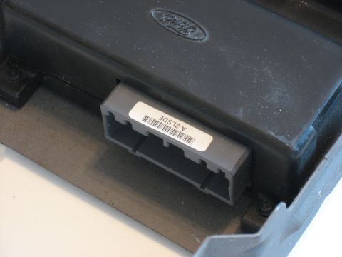 2001 Ford Crown Victoria - Close-up of a Ford electronic control unit, showing a connector and a label with text and a barcode.