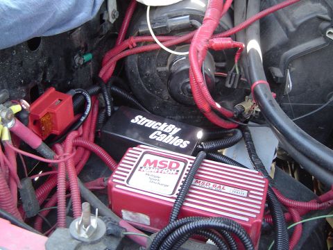 1989 Ford Bronco - Close-up of aftermarket ignition and wiring components installed in a vehicle's engine bay.