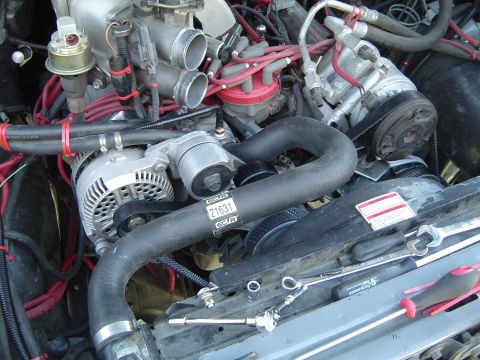 1989 Ford Bronco - Tools are staged around the engine bay, ready for work on the alternator, distributor, and hoses.