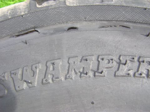 2000 Chevrolet Tahoe - A close-up of a damaged tire sidewall shows the embossed lettering 'SWAMPER' and a Supermotors.net watermark.