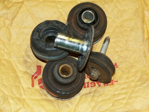 2001 Mercury Grand Marquis - A collection of worn body mount bushings and bolts, likely for an older vehicle, are displayed on a textured yellow surface.