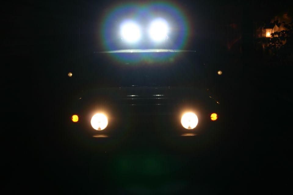 1996 Ford Bronco front view at night, headlights and roof lights illuminated