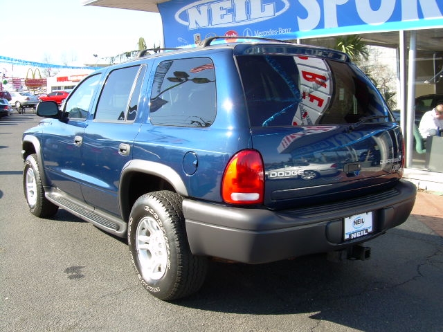 Blue 2003 Dodge Durango parked outside a dealership. Rear view