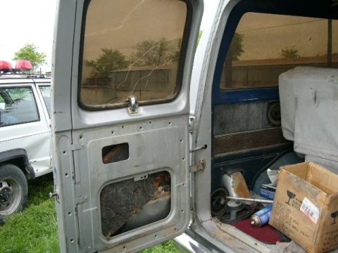 1978 Ford E250 - View inside a van, with a police SUV parked nearby.