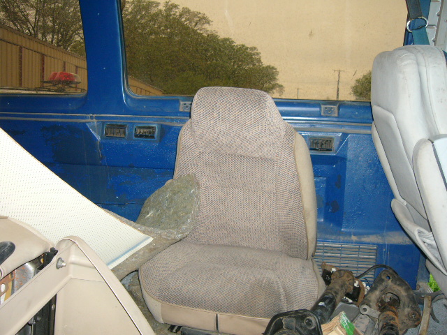 Interior view of a van showing two seats and blue paneling