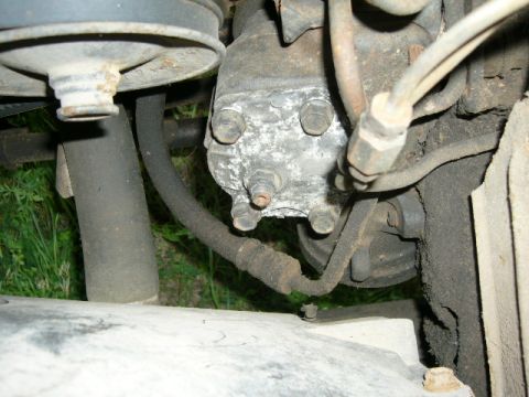 1978 Ford E250 - Close-up view of a vehicle's steering box and associated hoses, showing mechanical components.
