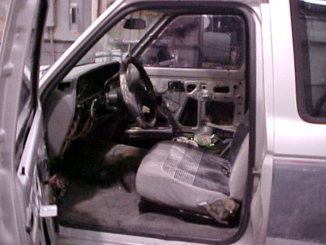 Interior of a Ford Ranger with door open, showing dashboard and seat removed