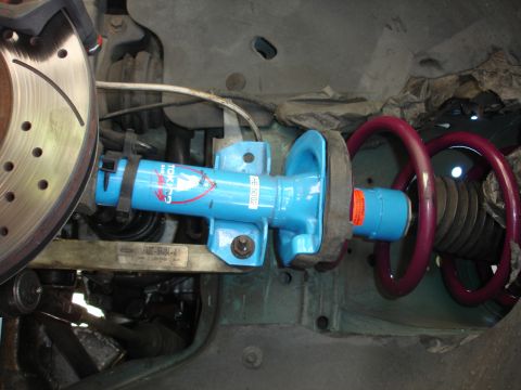 1993 Ford Taurus - Close-up of a blue Tokico shock absorber and red coilover spring assembly, with a vented brake rotor visible.