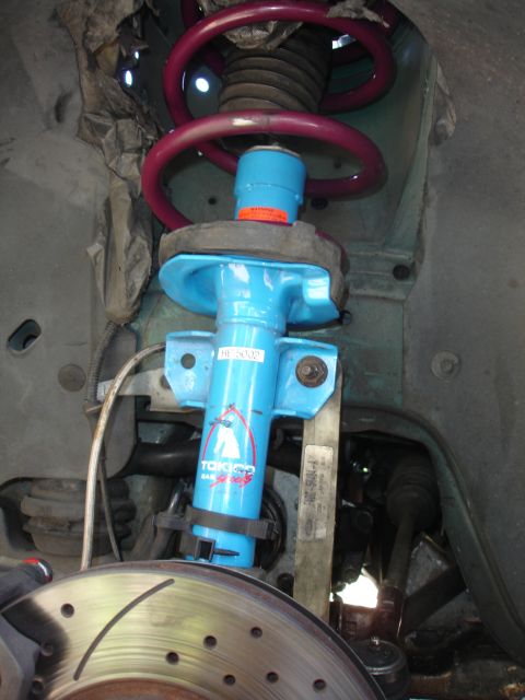 1993 Ford Taurus - Close-up view of a vehicle's front suspension components, including a shock absorber and brake rotor.