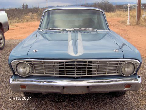 1964 Ford Ranchero - This classic car features a prominent chrome grille and dual headlights, with a distinctive silver stripe on its hood.