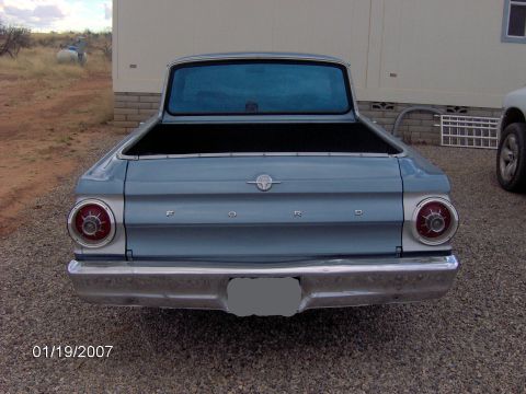 1964 Ford Ranchero - The rear of a light blue 1964 Ford Ranchero pickup truck is shown, its distinctive taillights and tailgate lettering.