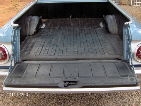 1964 Ford Ranchero - Rear view of a 1964 Ford Ranchero's bed, a rubber mat and open tailgate.