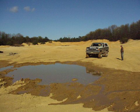 1989 Ford Bronco - 1989 Ford Bronco in a desolate, muddy, and sandy outdoor location.