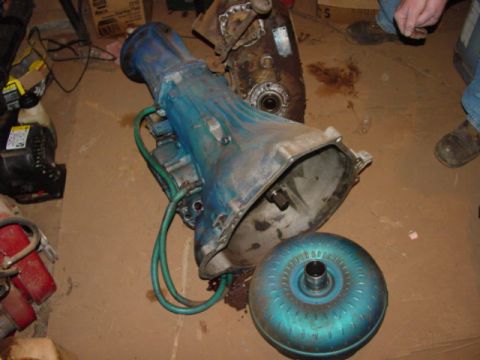 1986 Ford Bronco - A blue transmission and its matching torque converter are shown disassembled on a floor.