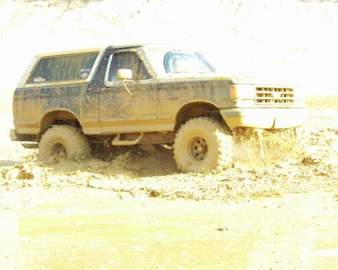 1989 Ford Bronco - Muddy 1989 Ford Bronco struggling through thick mud.