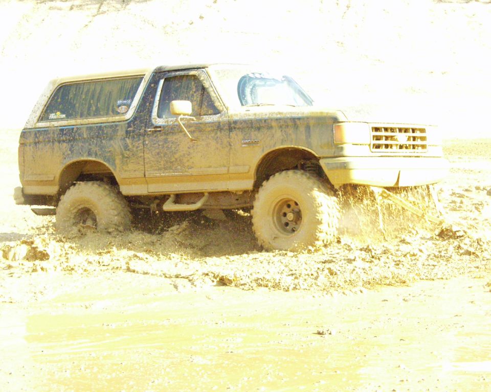 1989 Ford Bronco stuck in mud, front passenger side visible