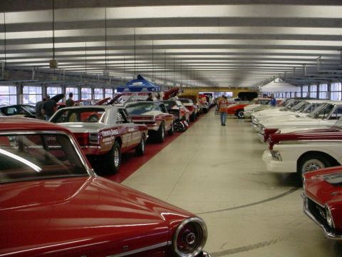 1972 Ford Ranchero - Rows of classic cars displayed indoors, with attendees browsing the collection.